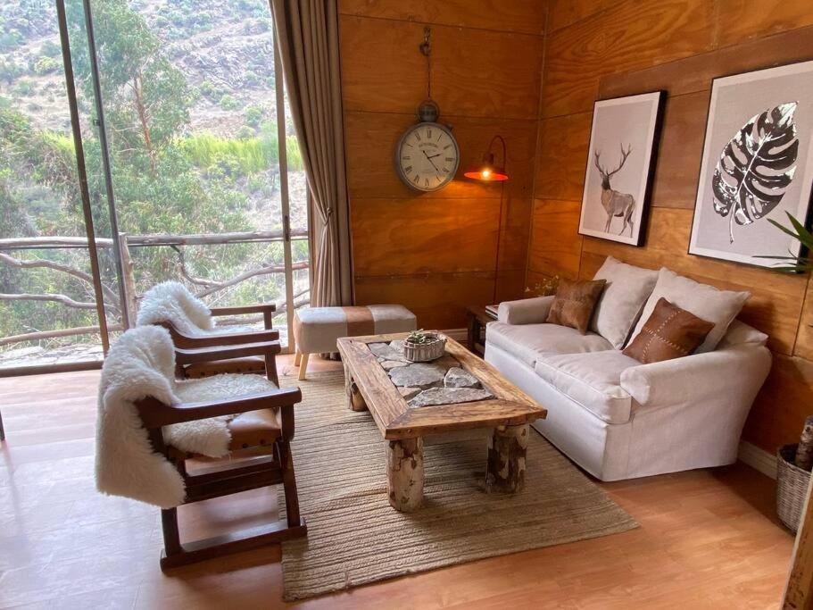 Casa Ñilhue, Camino a la Farellones في سانتياغو: غرفة معيشة مع أريكة وطاولة