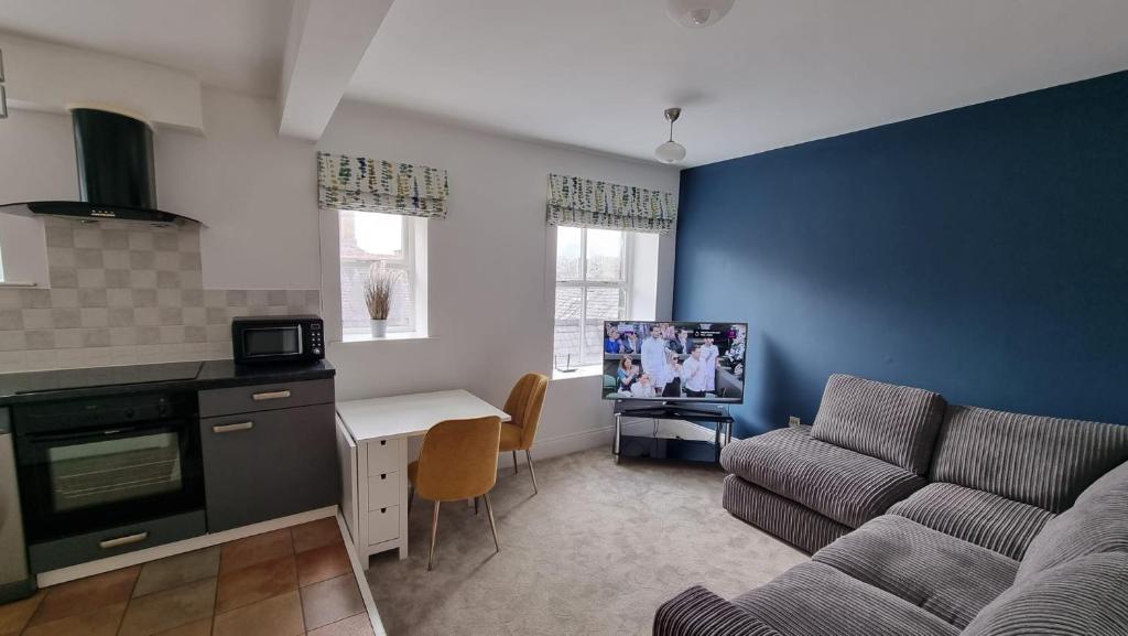 a living room with a couch and a tv in it at Cosy, Central Apartment Skipton in Skipton