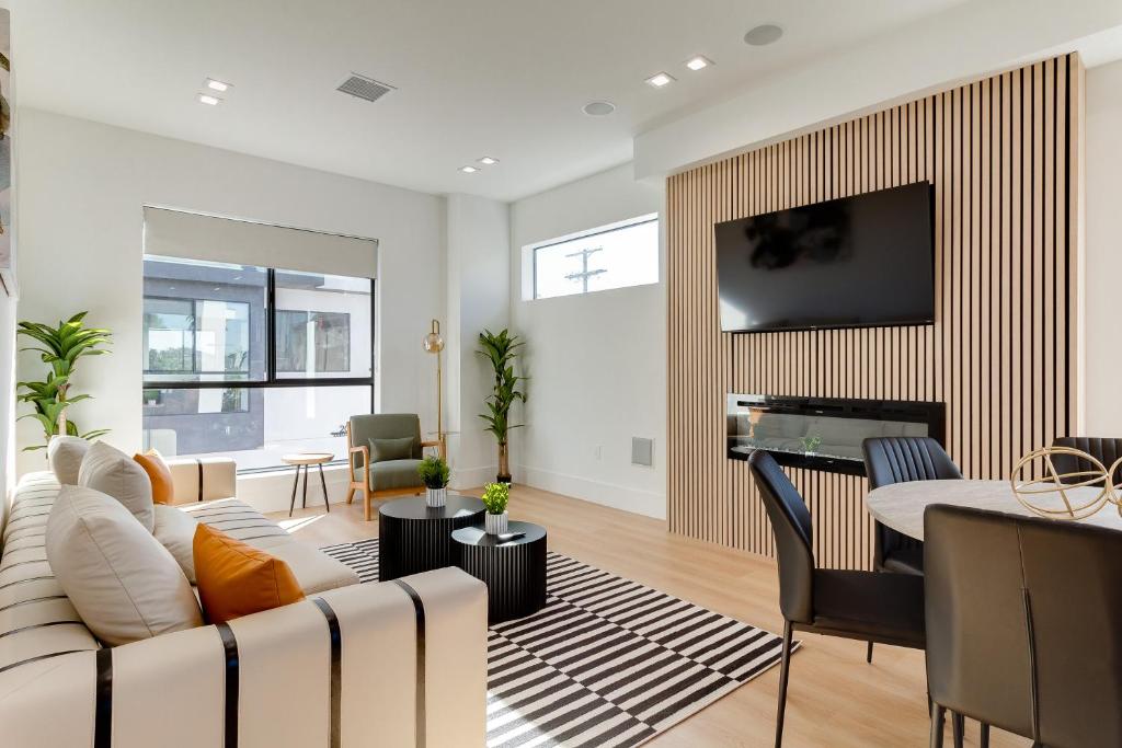 een woonkamer met een witte bank en een piano bij Brand New Modern 4 Bedroom House Pickfair Village in Los Angeles