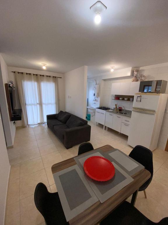 ein Wohnzimmer mit einem Tisch und einer roten Platte darauf in der Unterkunft Guilhermina II - 2 dormitórios com varanda - WI FI - chuveiros modernos à gás - estacionamento gratuito 400 metros da praia, Business home office in Praia Grande