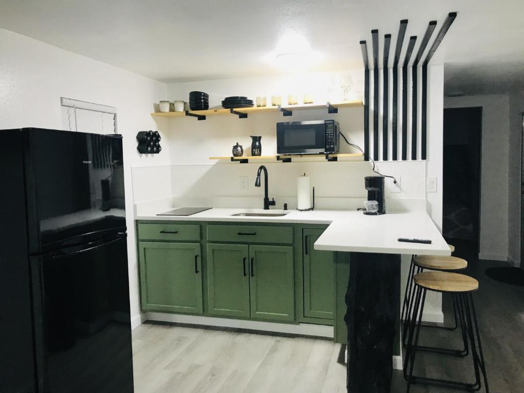 uma cozinha com armários verdes e um frigorífico preto em 10515 Houston Avenue em Hudson