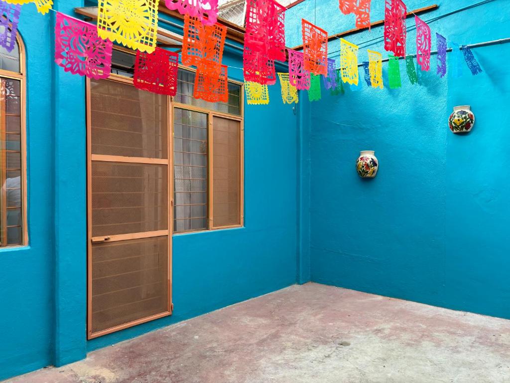 Zimmer mit blauer Wand und bunten Flaggen in der Unterkunft Casa Cruz, Oaxaca in Oaxaca de Juárez