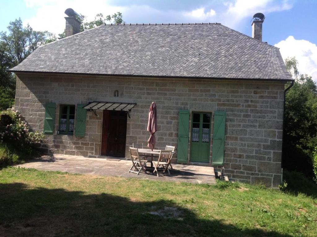 a small brick house with a table and chairs at Gîte de France Les belettes 3 épis - Gîte de France 4 personnes MAE-0304 in Chaumeil