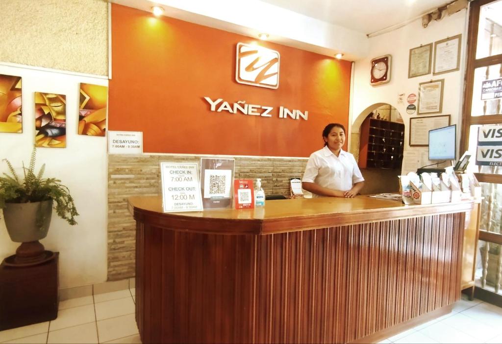 Hotel Yañez Inn في اياكوتشو: امرأة تجلس في كونتر في مطعم