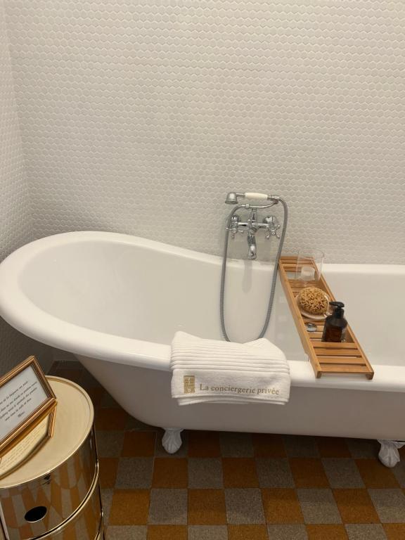a bathroom with a bathtub with a tray of towels at Suite haussmannienne en Sologne in Vierzon