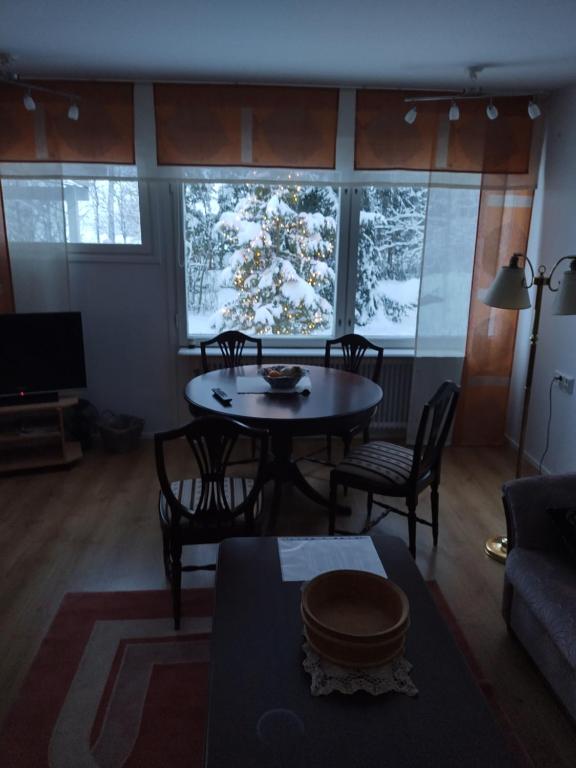 a living room with a table and chairs in front of a window at saarnimaja in Hämeenlinna