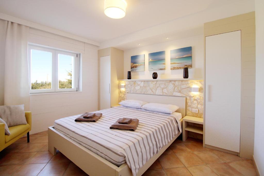 een slaapkamer met een bed met twee handdoeken erop bij Asinara Appartment in Sorso