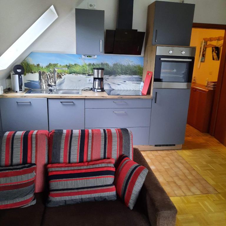 a kitchen with two chairs and a kitchen with a counter at Kulumheide 