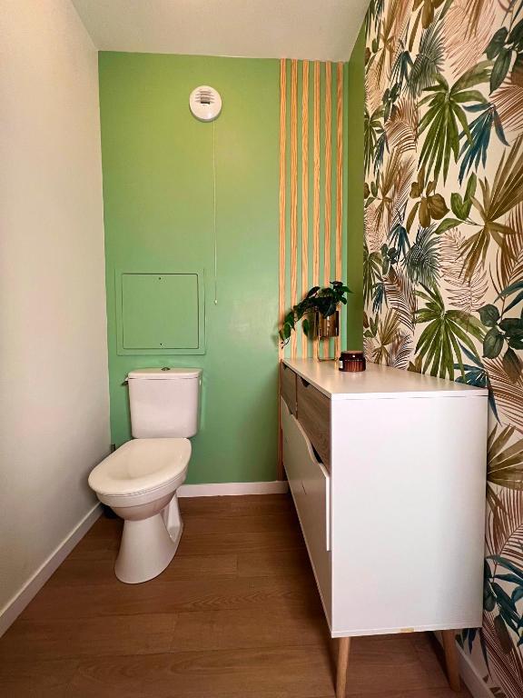 a bathroom with a toilet and a green wall at SSP Suites- Cosy &amp; Bel appartement 4 pièces 3 chambres 90M2 avec balcon in Épinay-sur-Seine