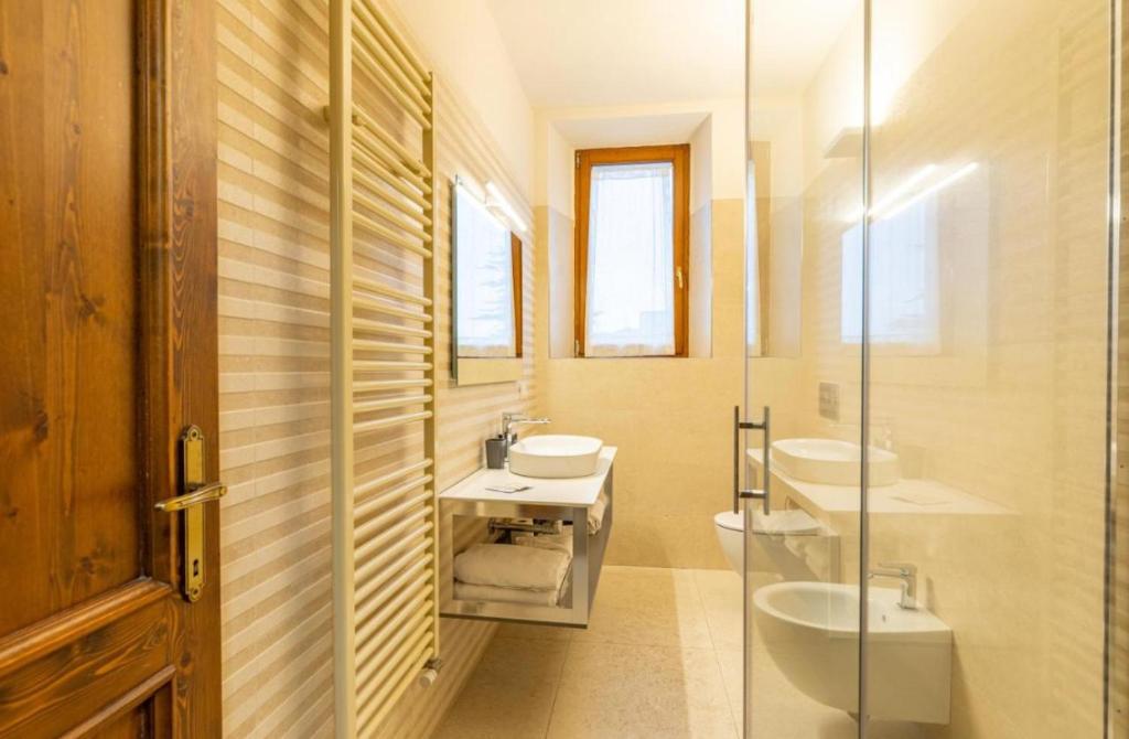 uma casa de banho com 2 lavatórios e uma cabina de duche em vidro. em Residenza San Donato em Montepulciano