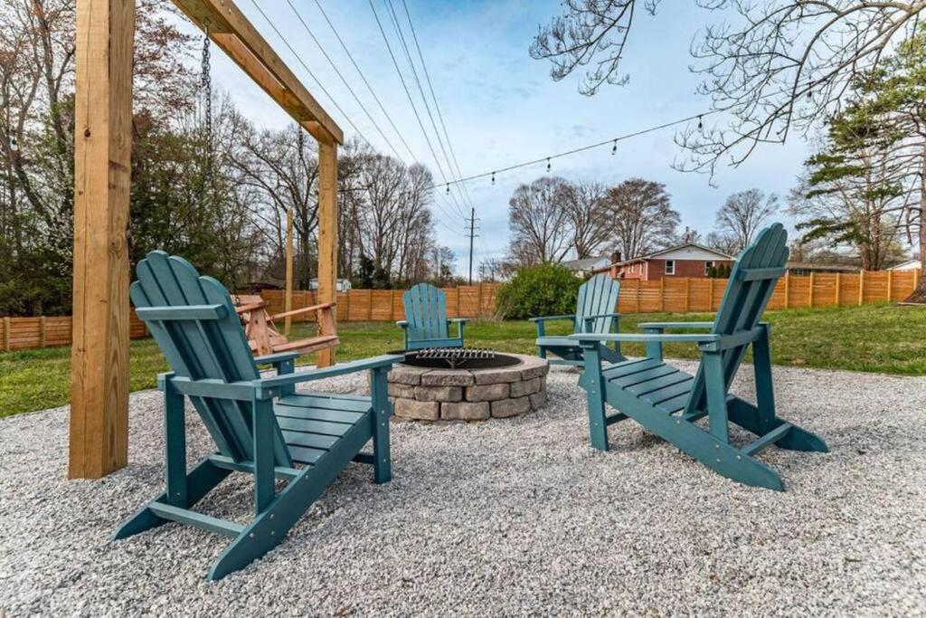 tres sillas azules sentadas al lado de una hoguera en Pet Friendly House with Bike Trail Access and Huge Fenced Yard en Greenville
