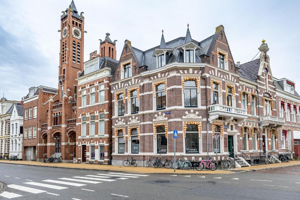 een groot bakstenen gebouw met een klokkentoren op een straat bij Luxe appartement in centrum van Groningen! in Groningen