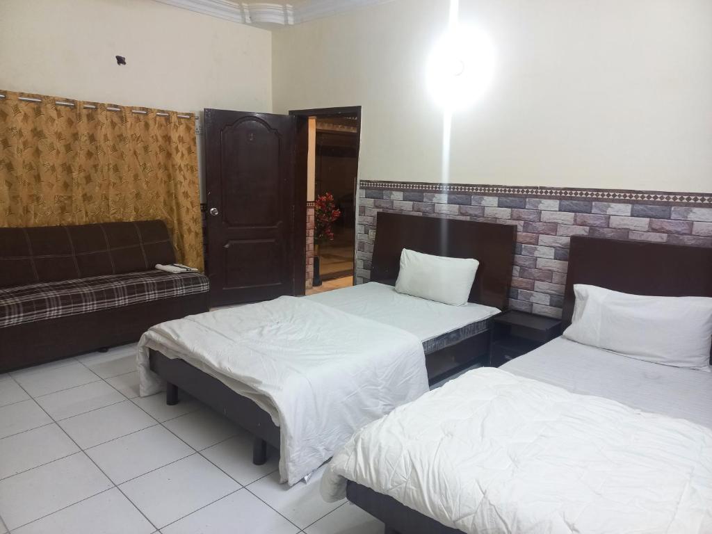1 dormitorio con 2 camas y sofá en New Al Rehman Guest House, en Hyderabad