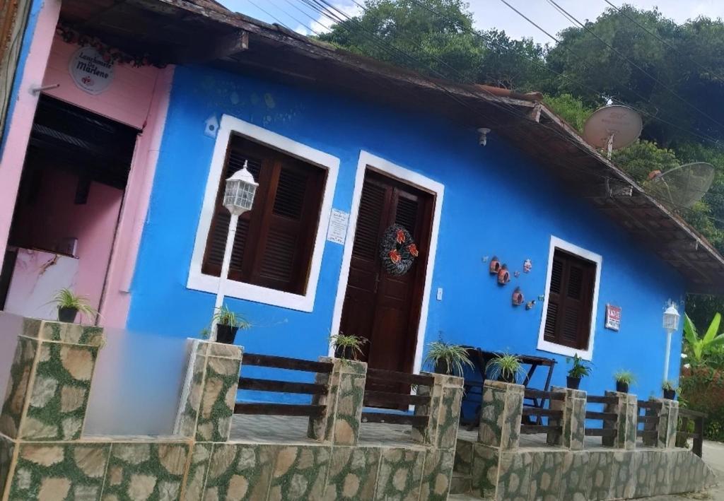 uma casa azul e rosa com uma cerca em Casa da Marlene em Guaramiranga