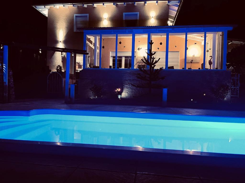 a house with a swimming pool at night at 5 Sterne Centurion Ferienhaus Villa 2 Pools 86 Zoll TV in Aldersbach