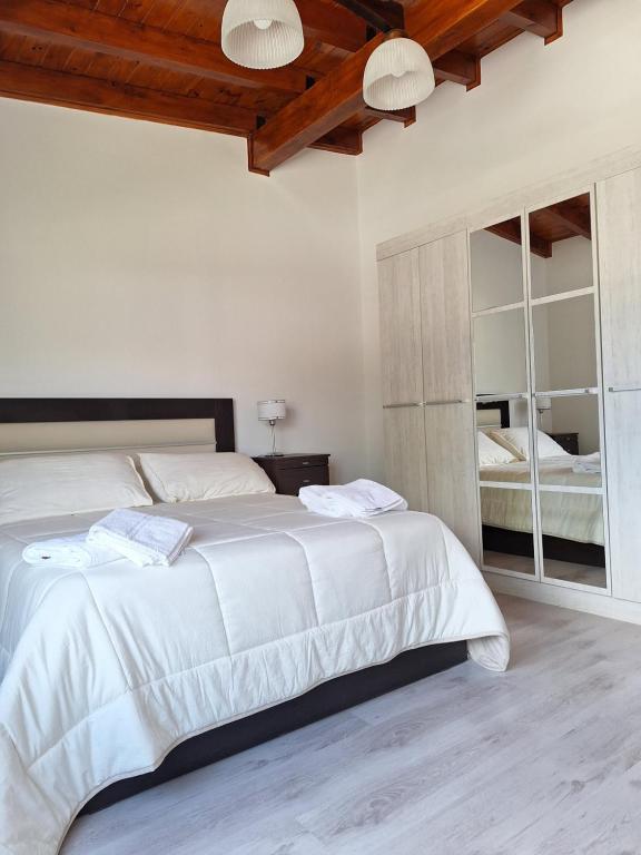 um quarto com uma grande cama branca e um espelho em Cordillera sur em Esquel