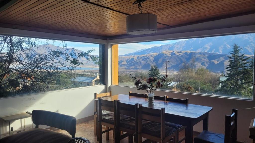 a dining room with a table and a view of mountains at La Inesita in Tafí del Valle