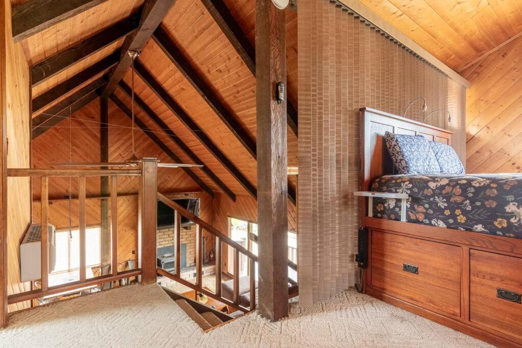 Cette chambre mansardée comprend un lit et un plafond en bois. dans l'établissement The Badger House, à Badger