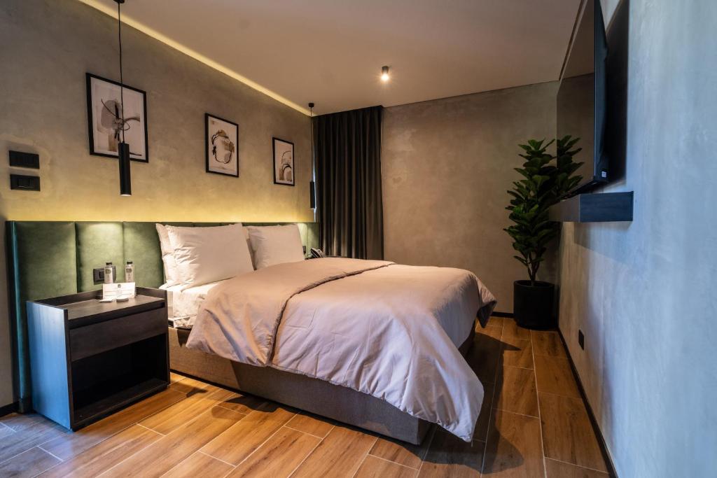 1 dormitorio con cama y mesita de noche con planta en ALCALÀ EXPO en Guadalajara