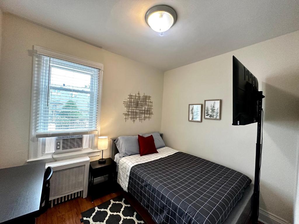 een slaapkamer met een bed en een flatscreen-tv bij 10-A Diamond in Yonkers, NY in Yonkers
