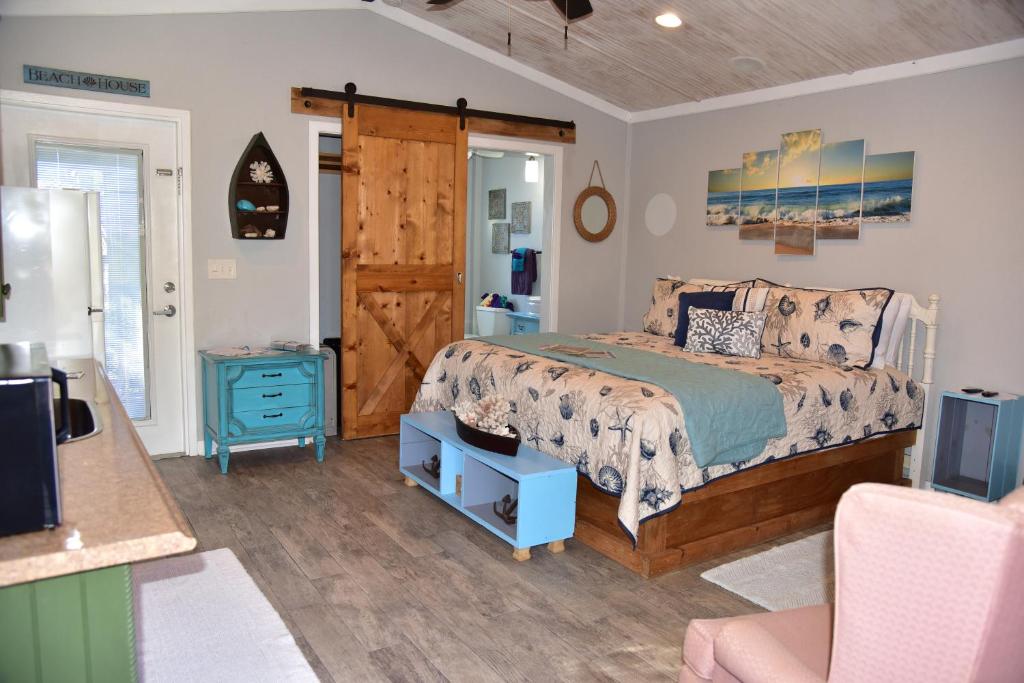 a bedroom with a bed and a desk and a tv at The Beach House at Si Como No Inn in Flagler Beach