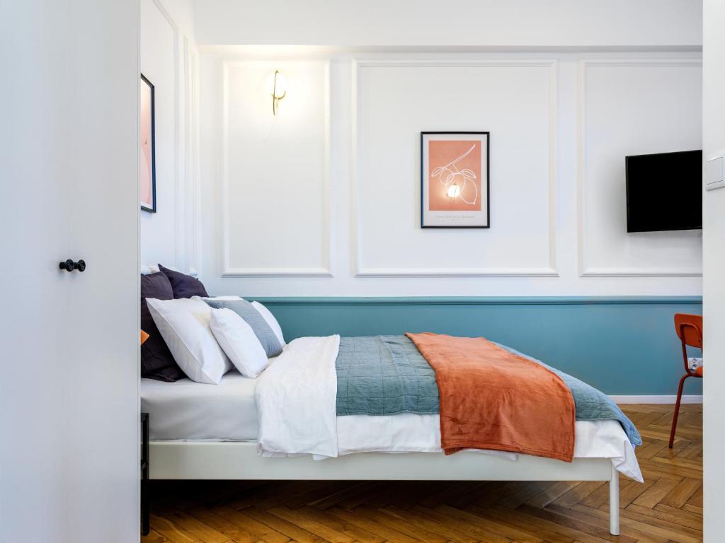 um quarto com uma cama com uma parede azul em PlayRoom Aparthotel em Cracóvia
