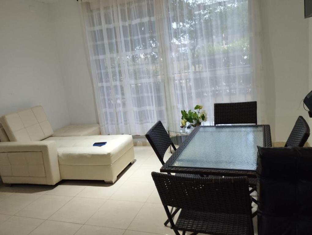 a living room with a couch and a table and chairs at Apto de 3 habitaciones con ventiladores y parqueadero comunal in Valledupar