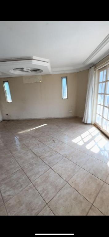 ein leeres Zimmer mit Fliesenboden und Fenstern in der Unterkunft Guest House Iguaçu in Foz do Iguaçu