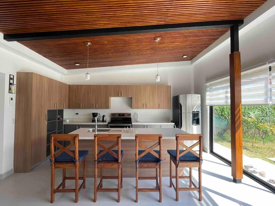 een keuken met 3 stoelen en een tafel met een aanrecht bij Casa Pacifico 46 Tamarindo in Santa Cruz