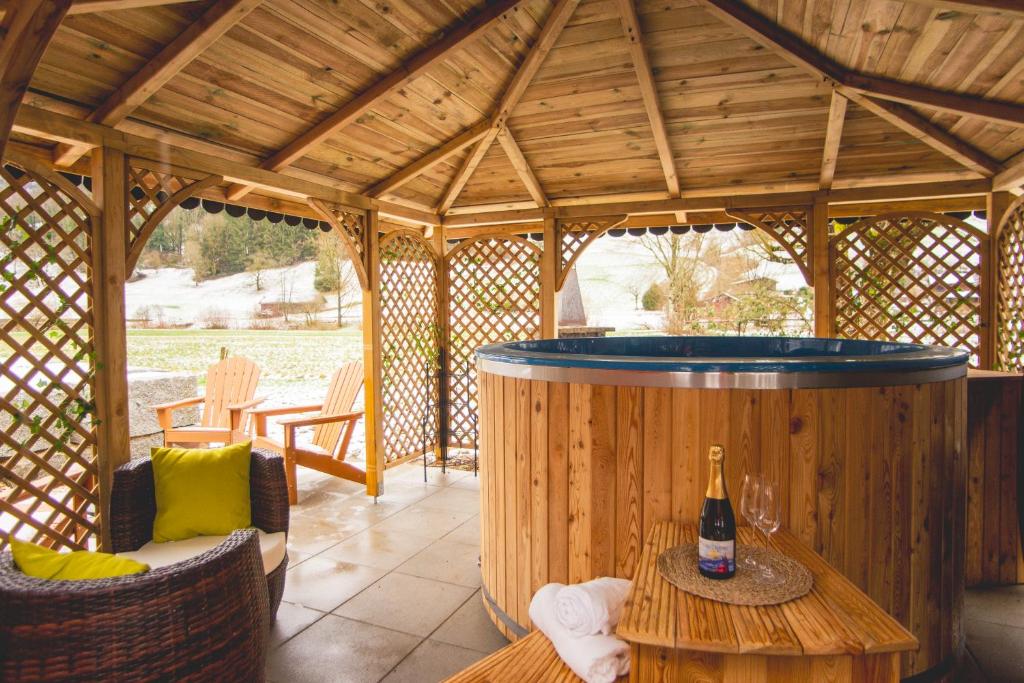 a large wooden gazebo with a hot tub at Le Chalet Bed&Bath -Chez Les Alfreds in Soubey