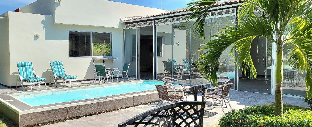 a patio with a table and chairs next to a pool at Casa Finca Jaccuzi Aire Acondicionad Wifi TV in Ricaurte