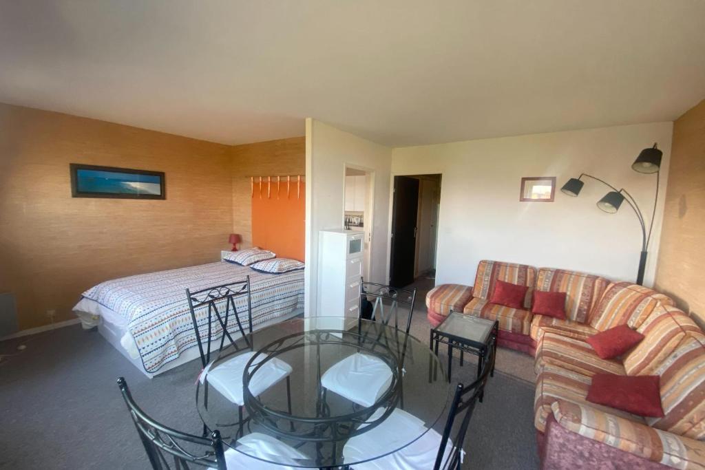 une chambre d'hôtel avec un lit et une table en verre dans l'établissement Cozy love cocoon of 34 m direct access to the sea, à Bernières-sur-Mer