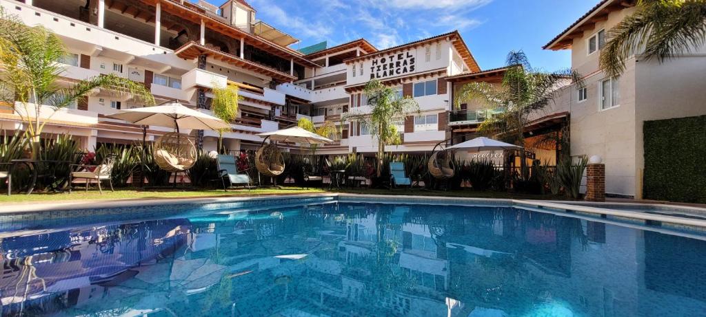 a swimming pool in front of a building at Hotel Tierras Blancas in Valle de Bravo