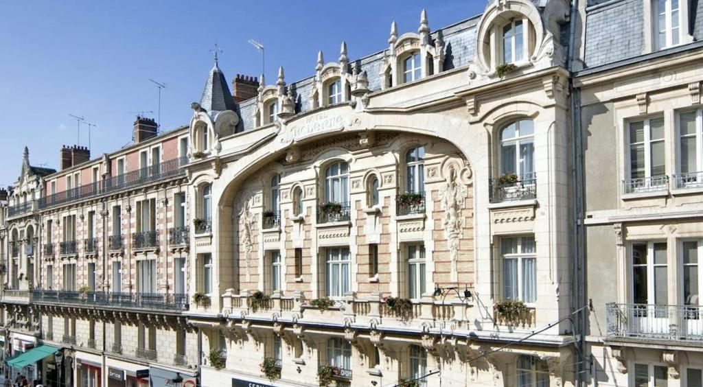 ein großes Gebäude mit Fenstern und Wasser davor in der Unterkunft Best Western Hôtel d'Arc in Orléans