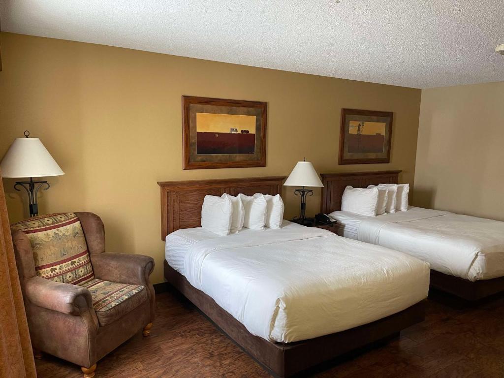ein Hotelzimmer mit 2 Betten und einem Stuhl in der Unterkunft Best Western Plus Kelly Inn & Suites in Billings
