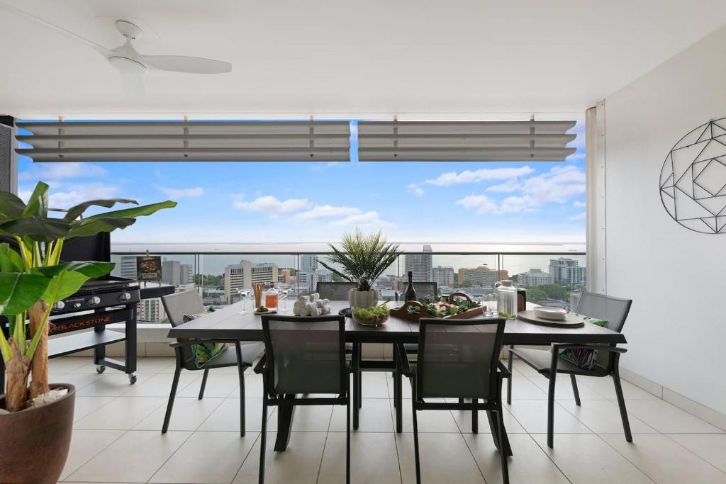 a dining room with a table and chairs and a large window at 'High-Top Retreat' City Chic With Ocean Outlooks in Darwin