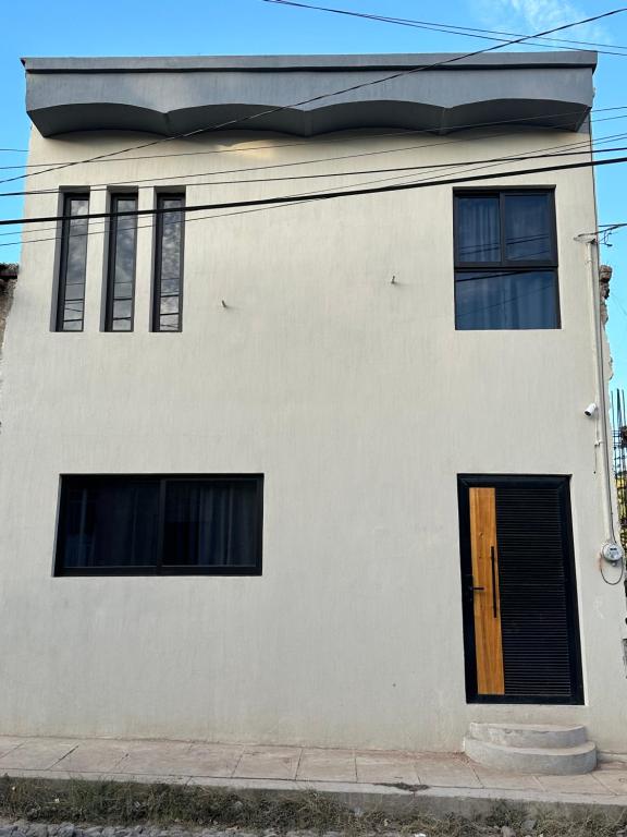テキーラにあるCasa Landeros y Osunaの白い建物(ドア、窓2つ付)