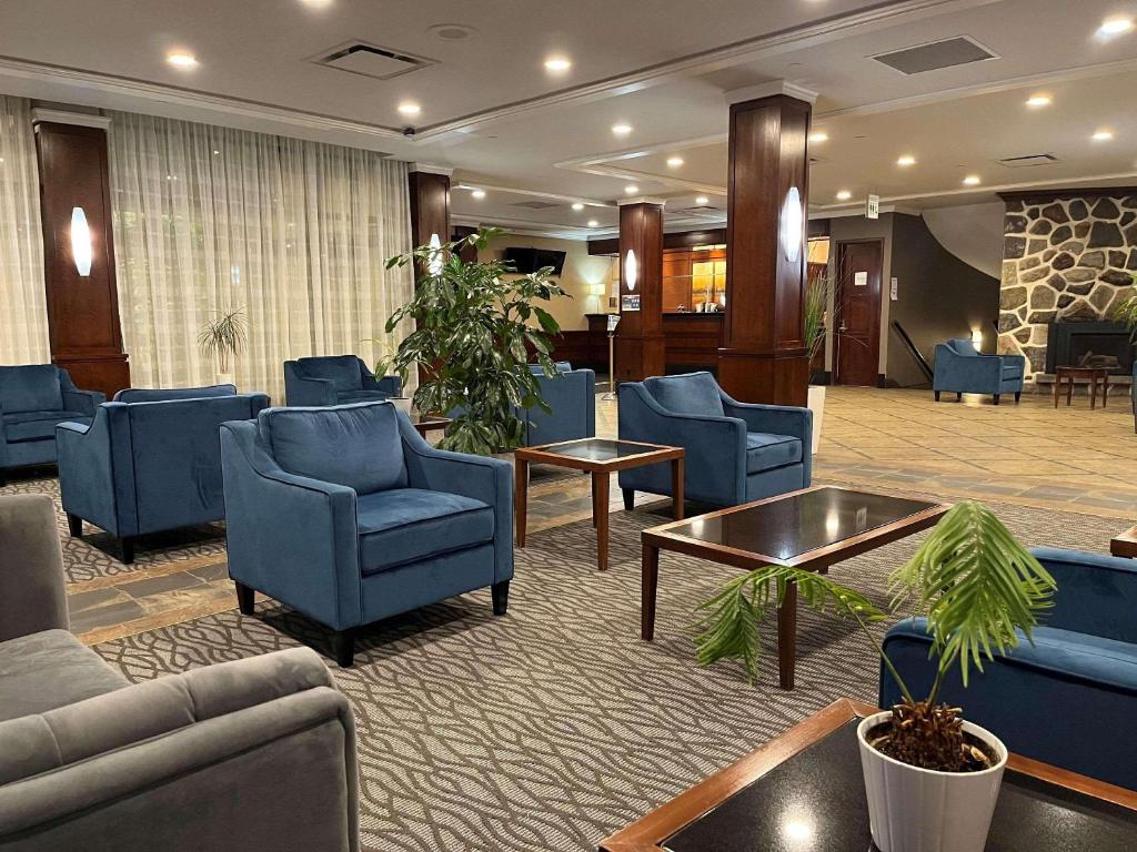 um átrio de hotel com cadeiras azuis e uma sala de espera em Radisson Hotel Montreal Airport em Ville Saint Laurent