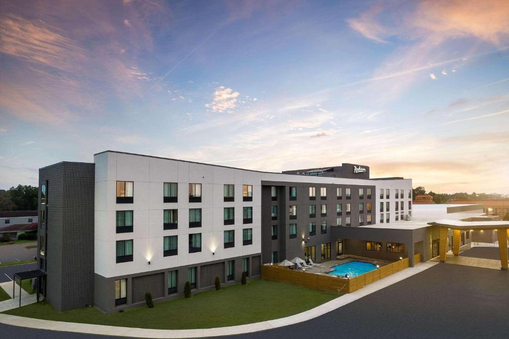 un gran edificio blanco con una piscina frente a él en Radisson Hotel West Memphis, en West Memphis