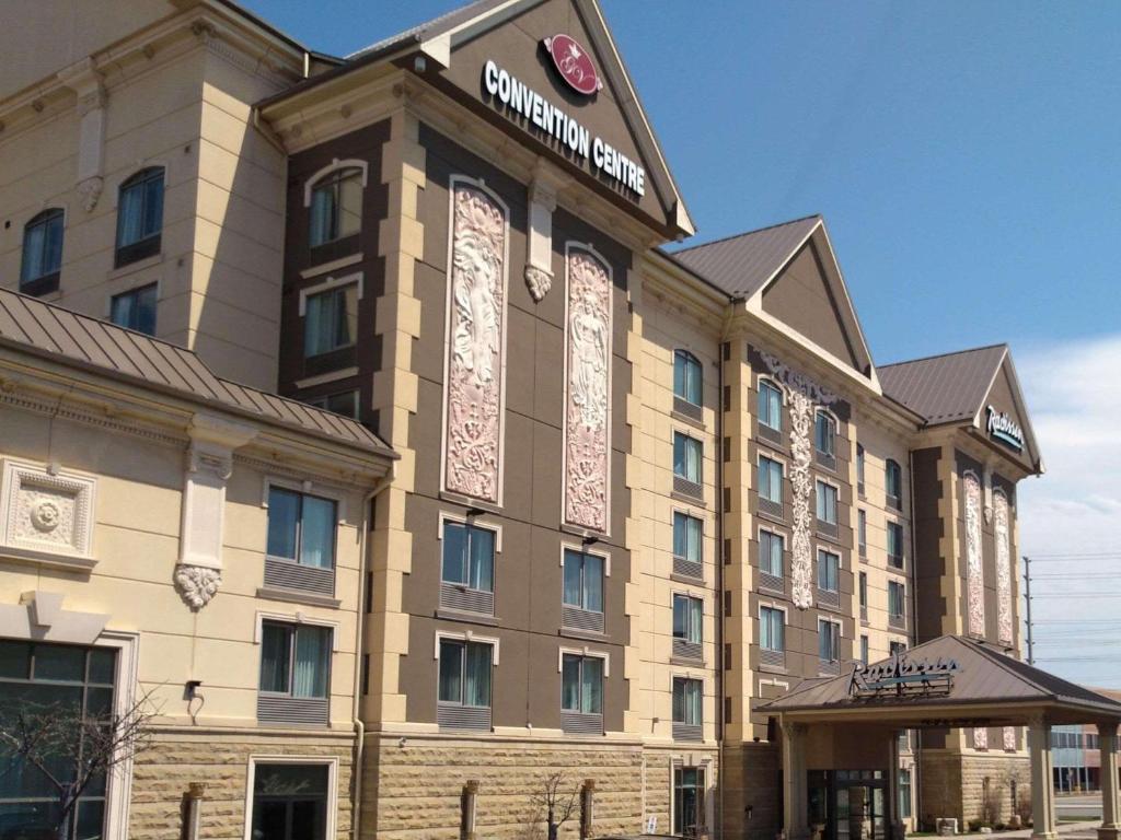 a building with a sign on the front of it at Radisson Toronto Airport West in Mississauga