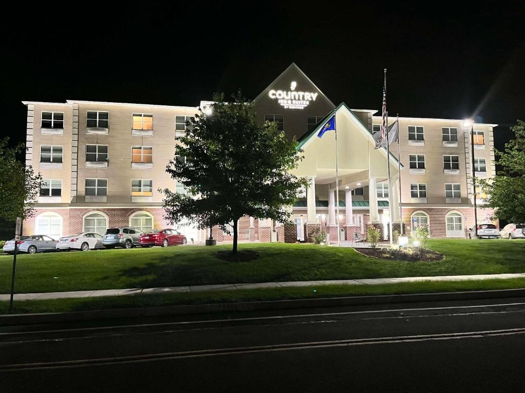 un gran edificio con un cartel en la parte delantera en Country Inn & Suites by Radisson, Harrisburg - Hershey West, PA, en Harrisburg