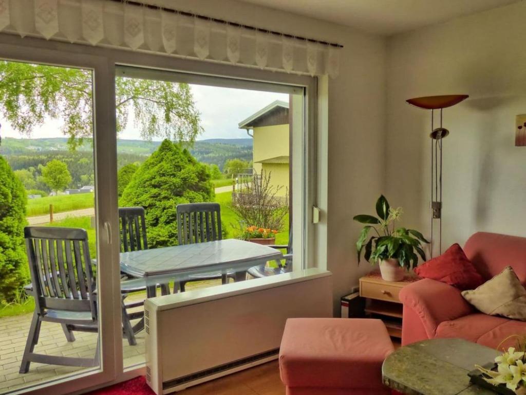 a living room with a glass door leading to a patio at Holiday home Oertel Häusl in Niederlauterstein