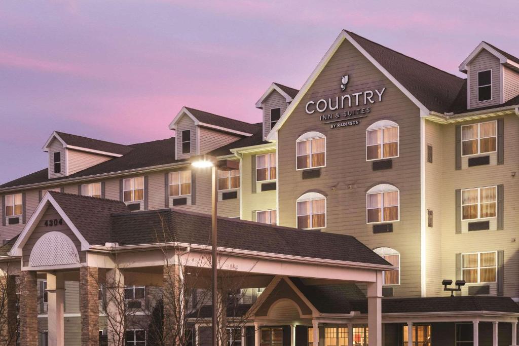 una representación del hotel del patio al anochecer en Country Inn & Suites by Radisson, Bentonville South - Rogers, AR, en Rogers