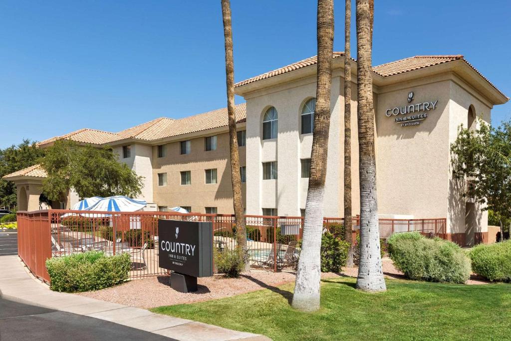 Country Inn & Suites by Radisson, Phoenix Airport, AZ في فينكس: فندق فيه لافته امام مبنى