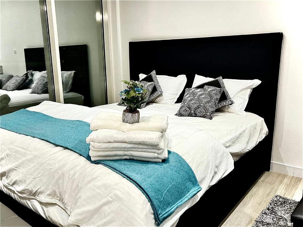 Una cama con toallas y un jarrón de flores. en Brand new Modern Studio High Floor near Burj en Dubái