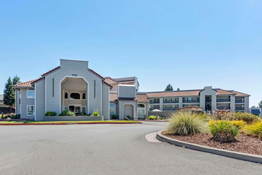 a house with a road in front of a building at Country Inn & Suites by Radisson, Vallejo Napa Valley, CA in Vallejo