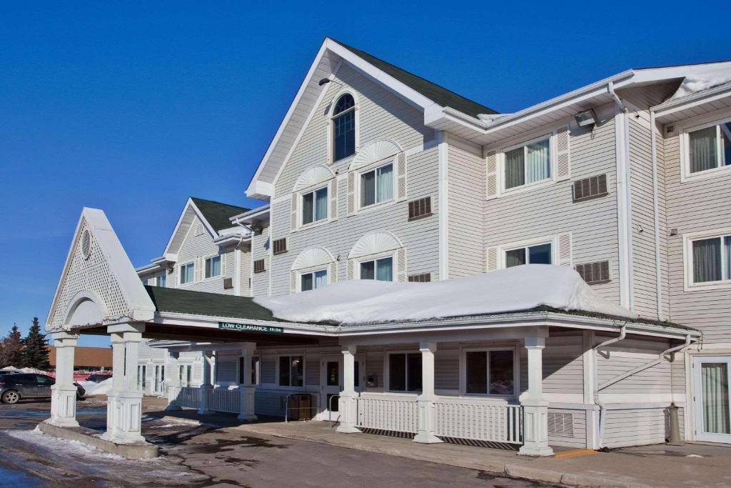 un gran edificio blanco con nieve en el techo en Country Inn & Suites by Radisson, Saskatoon, SK en Saskatoon