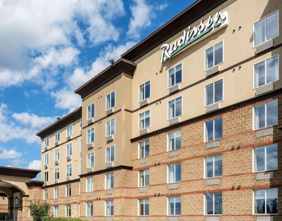 a hotel with a sign on the side of a building at Radisson Hotel & Suites Fort McMurray in Fort McMurray