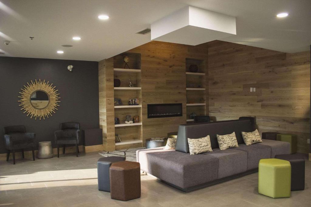 uma sala de estar com um sofá e uma televisão em Country Inn & Suites by Radisson, Niagara Falls, ON em Cataratas do Niágara
