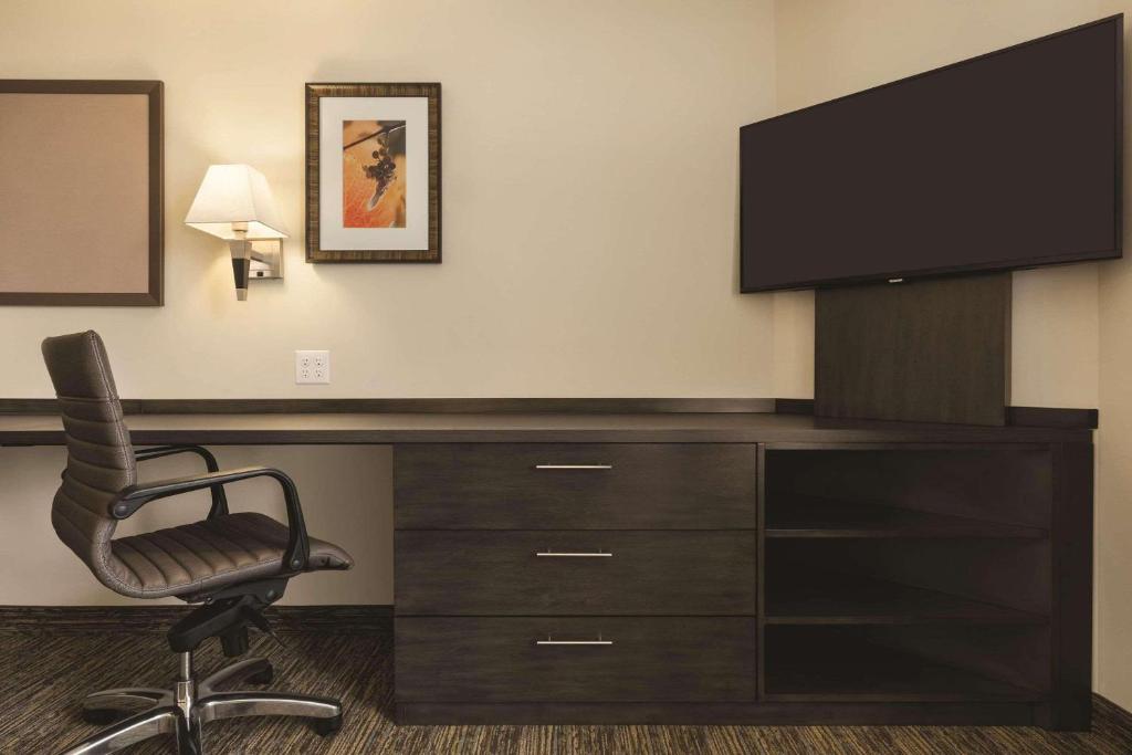 a desk with a television and a chair in a room at Park Inn by Radisson, Calgary Airport North, AB in Calgary